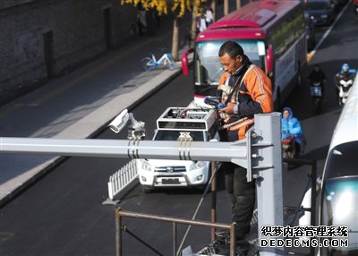 11月14日,崇文门外大街,工作人员正在安装道路停车电子收费高位视频监控设备。新京报记者 王贵彬 摄