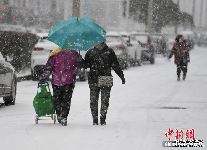  11月13日，长春市民在街头冒雪出行。 张瑶 摄