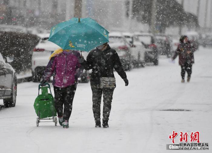 11月13日,长春市民在街头冒雪出行。 张瑶 摄