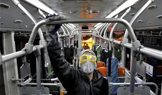 2月26日，在伊朗首都德黑兰，工作人员在为公交车辆消毒。图源：新华社