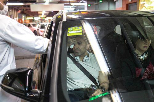 3月5日，在伊朗德黑兰，一名安保人员为出入商场停车场的顾客测量体温。新华社发（艾哈迈德·哈拉比萨斯摄）
