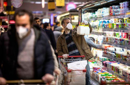 3月5日，在伊朗德黑兰，人们佩戴口罩购物。新华社发（艾哈迈德·哈拉比萨斯摄）