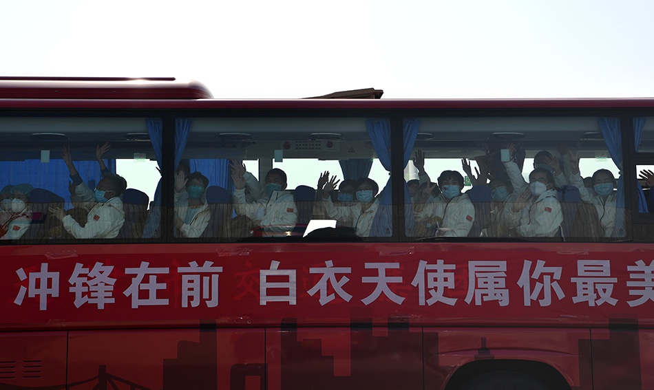 3月17日，在天津滨海国际机场，返乡的医疗队队员向前来接机的人们挥手致意。新华社记者 李然 图
