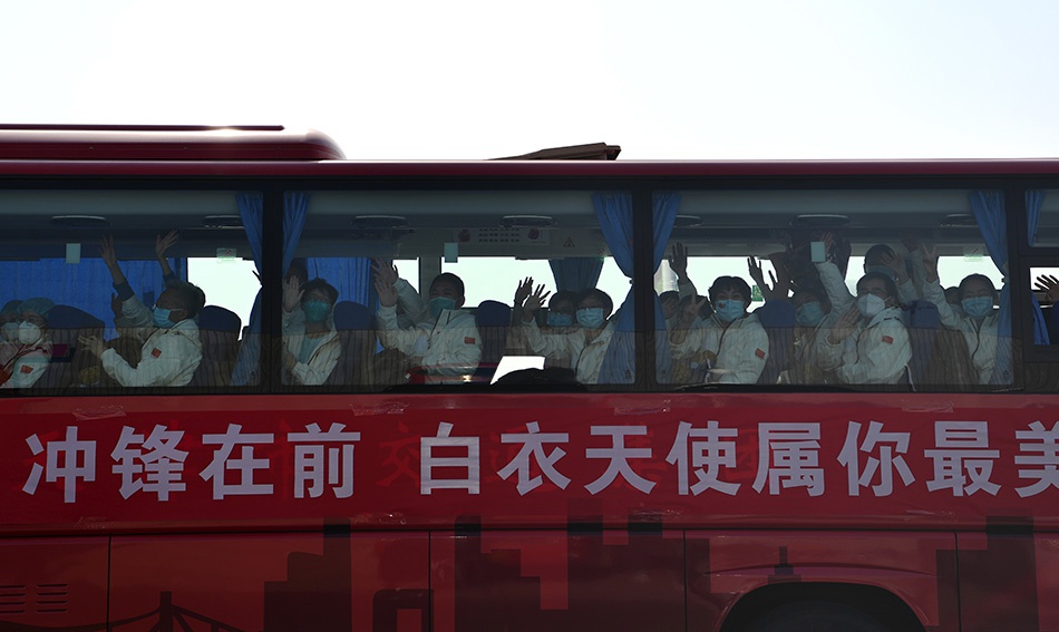 3月17日,在天津滨海国际机场,返乡的医疗队队员向前来接机的人们挥手致意。新华社记者 李然 图
