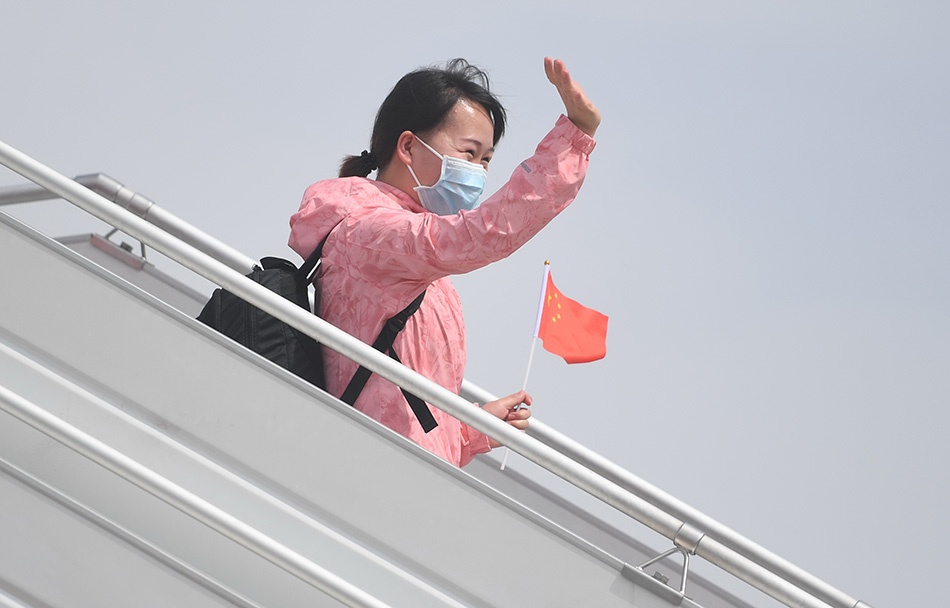 3月18日，乘机抵达石家庄正定国际机场的河北省援鄂医疗队队员向接机人员挥手致意。新华社记者 朱旭东 图