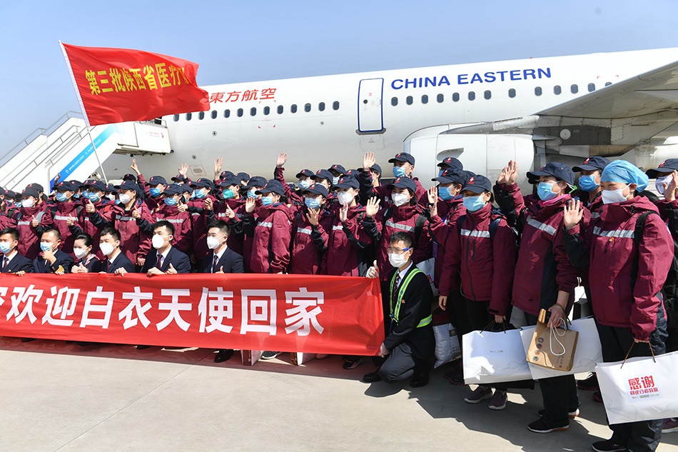 3月18日,回家的医疗队队员与机组人员合影。当日,陕西省援鄂医疗队第三批队员和陕西省中医医疗队队员共170人,分别乘坐东航两架航班抵达西安咸阳国际机场。新华社发(袁景智 图)