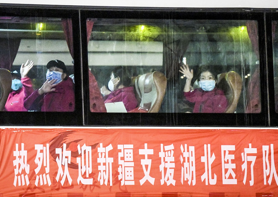 3月17日,在新疆乌鲁木齐地窝堡国际机场,返乡的医疗队队员坐上大巴车准备离开。新华社记者 王菲 图