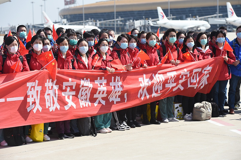  3月18日，从武汉返回的安徽援鄂医疗队员在合肥新桥国际机场参加欢迎仪式。当日，374名安徽省支援湖北抗疫的医疗队员从武汉乘飞机返回合肥。新华社发（周牧 图）