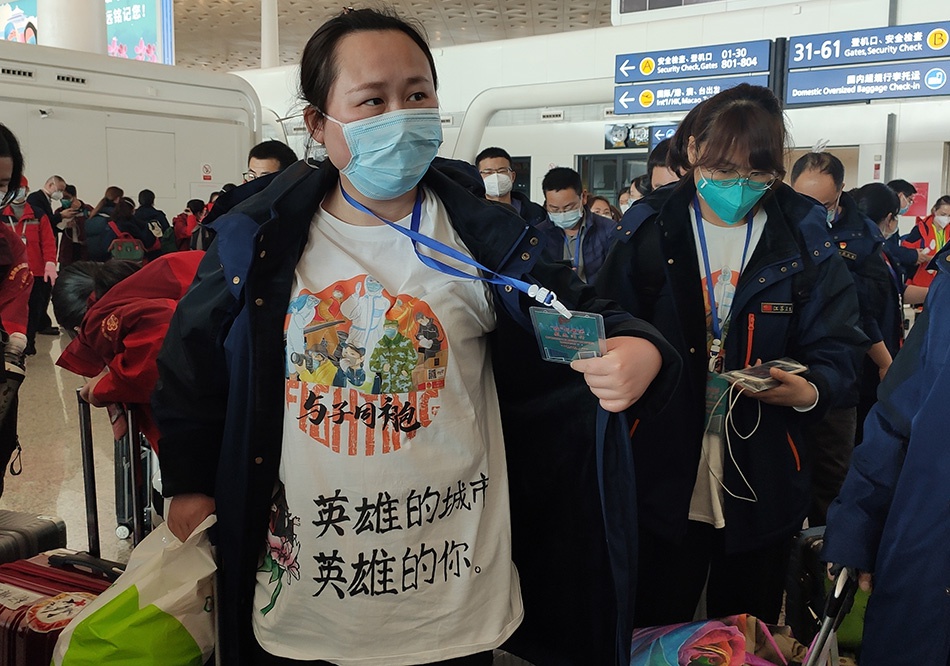 与子同袍！3月17日，江苏第一批援鄂医疗队队员穿着赠送的“武汉小学生手绘纪念衫”踏上返乡之旅。澎湃新闻记者 郑朝渊 图