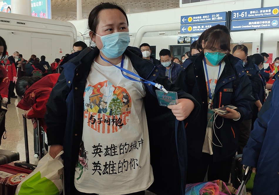 与子同袍!3月17日,江苏第一批援鄂医疗队队员穿着赠送的“武汉小学生手绘纪念衫”踏上返乡之旅。澎湃新闻记者 郑朝渊 图