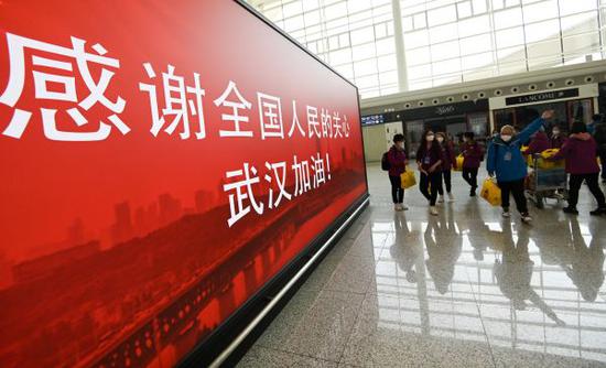 3月17日，准备登机的天津医疗队经过武汉天河机场候机楼内一处感谢标语。 （新华社）