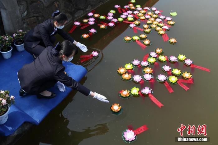  清明PC。3月25日，南京市仙灵陵园举行2020年清明集体代祭扫仪式，工作人员依次献花、敬香、鞠躬、默哀、放莲花灯，为故人祈福。图为工作人员放莲花灯。中新社记者 泱波 摄