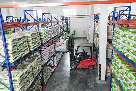 4月3日，重庆市江津区储备粮有限公司的成品大米仓库内，一名工作人员操作着装卸车辆装卸袋装大米。 新华社 图