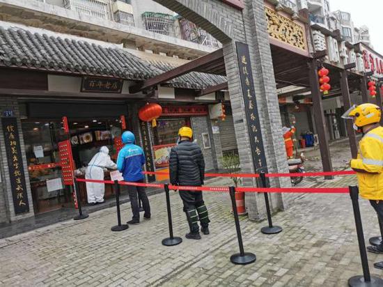 4月7日午时,店外保持距离排队买面的顾客。