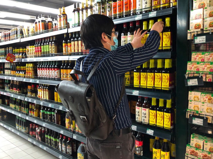 4月5日，市民戴口罩进入超市。摄影/新京报记者 解蕾