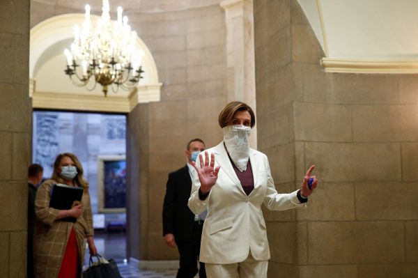 当地时间23日，美国众议院议长佩洛西佩戴着面罩，前往众议院参与一项4840亿美元的新冠肺炎援助法案的投票。（路透社）