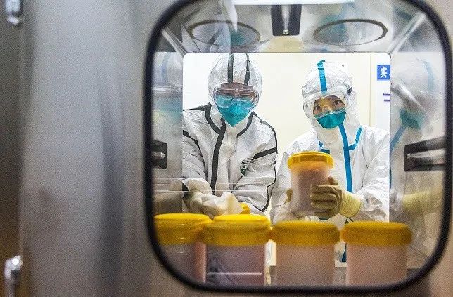 2 月 25 日,工作人员在中国疾病预防控制中心传染病预防控制所 P3 实验室传递窗口接收刚刚从浙江省疾控中心运抵的疫苗生产用新型冠状病毒毒株。