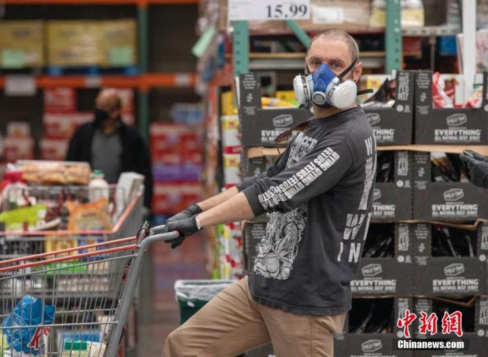 当地时间4月22日，位于美国旧金山湾区圣马特奥县的一家Costco超市内，顾客佩戴口罩购物。中新社记者 刘关关 摄