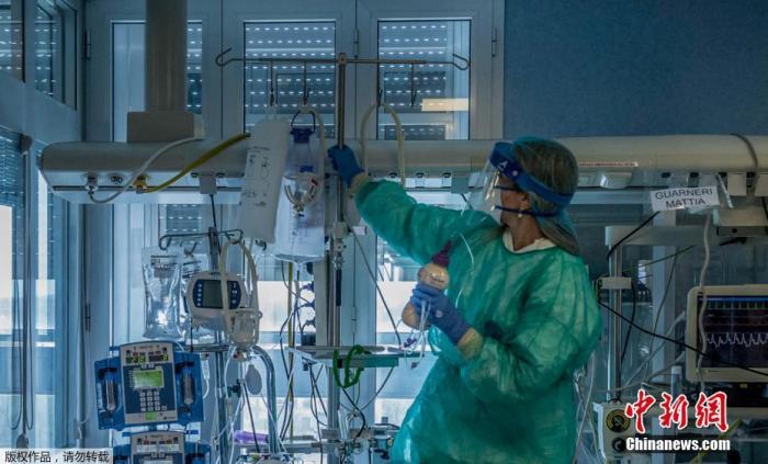 资料图：当地时间3月23日，意大利米兰东南部的克雷莫纳医院重症监护室，医护人员正在为感染新冠状肺炎的重症患者治疗。