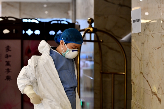  2月22日，采集完咽拭子后，贵州省遵义市汇川区疾控中心工作人员周灵君将厚厚的防护服慢慢脱下来。人民视觉供图