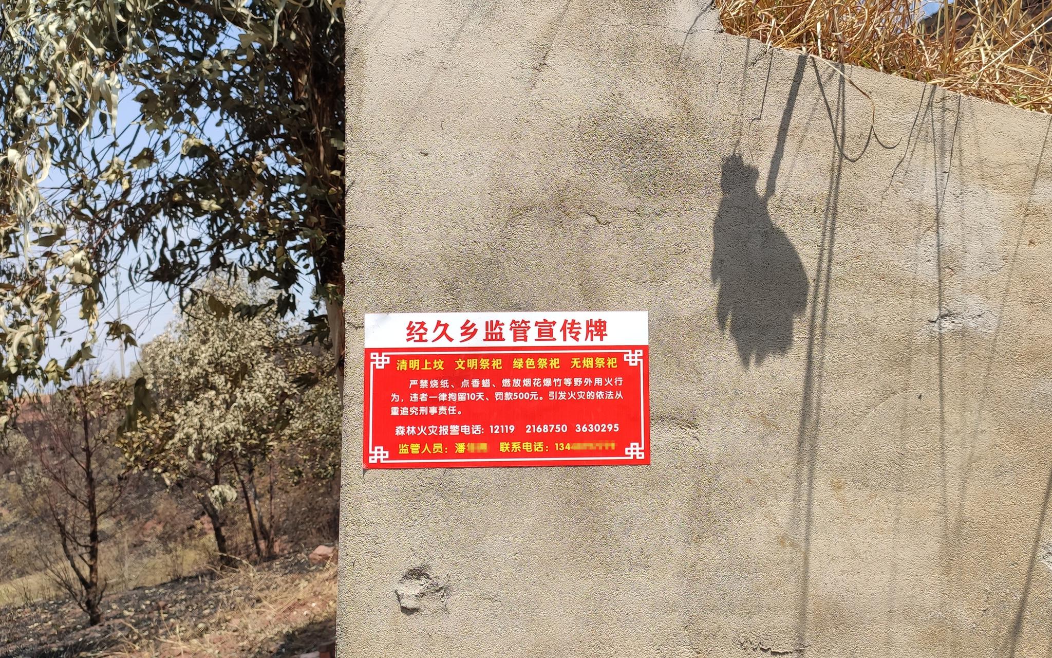 马鞍山村山上不少坟墓都贴了防火监管宣传牌。