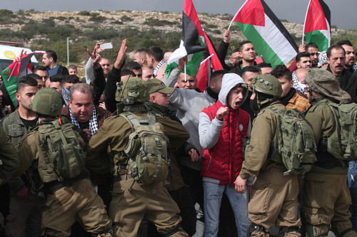 资料图片：1月29日，在约旦河西岸城市图巴斯东部的泰亚西尔检查站，巴勒斯坦示威者与以色列士兵对峙。新华社发
