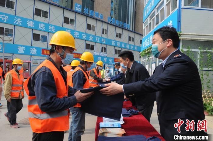 资料图：4月15日，北京市人力资源和社会保障部门到中建一局集团建设发展有限公司北京港澳中心改造项目工地送法规。北京市人力社保局供图