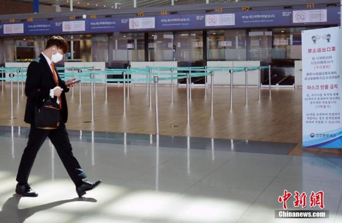  资料图：3月20日，韩国仁川国际机场，工作人员走过机场大厅。中新社记者 曾鼐 摄