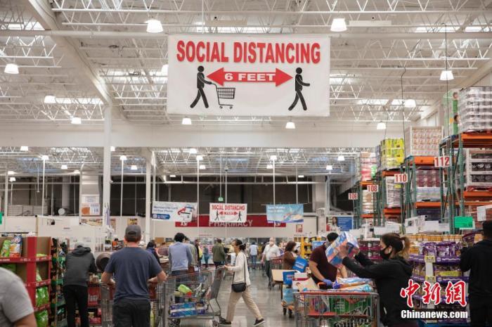当地时间5月3日，美国旧金山湾区一家超市挂出提醒顾客保持“社交距离”的醒目标识。 中新社记者 刘关关 摄