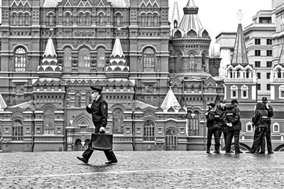  一名警察（左）经过俄罗斯莫斯科红场 摄影/新华