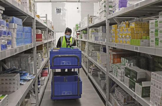 4月23日,在一家互联网医药企业的药品仓库内,工作人员正在处理互联网销售药品订单。图/IC