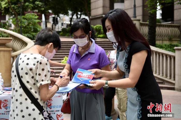 5月24日上午,市民纷纷来到街站签名支持。“香港各界撑国安立法联合阵线”于香港各区多个街站进行签名行动,位于上环新纪元广场的街站,有市民前来签名支持。 中新社记者 李志华 摄