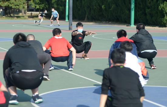 4月27日,福州第一中学体育老师(中)在体育课上指导学生做热身运动。新华社记者贺灿铃摄