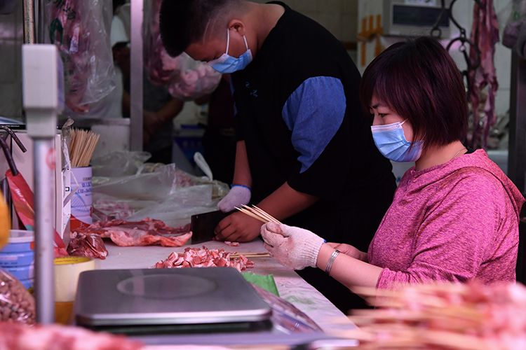 市场内经营者正在制作羊肉串。