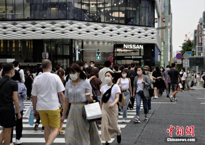 资料图：图为民众佩戴口罩走过日本东京街头。 中新社记者 吕少威 摄