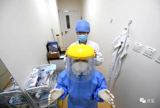 杨会娟（后）为第一次进入实验室的同事安娜带上面罩