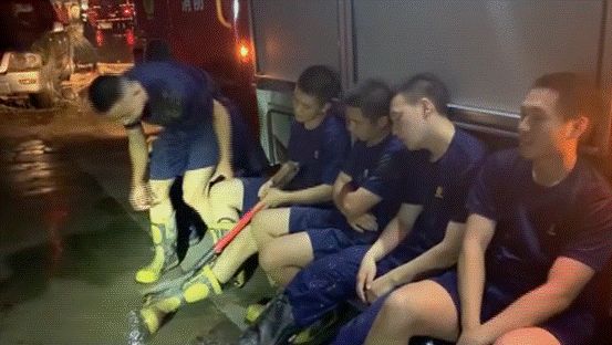 在车边休息的消防队员们