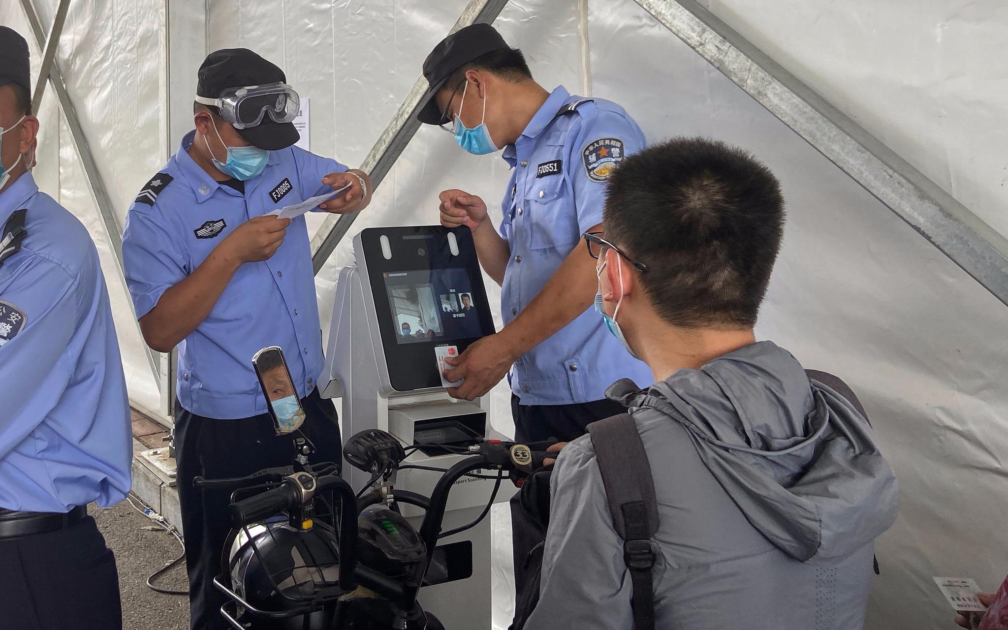白庙北检查站,民警正在查验出京人员的核酸证明。摄影/新京报记者 王贵彬