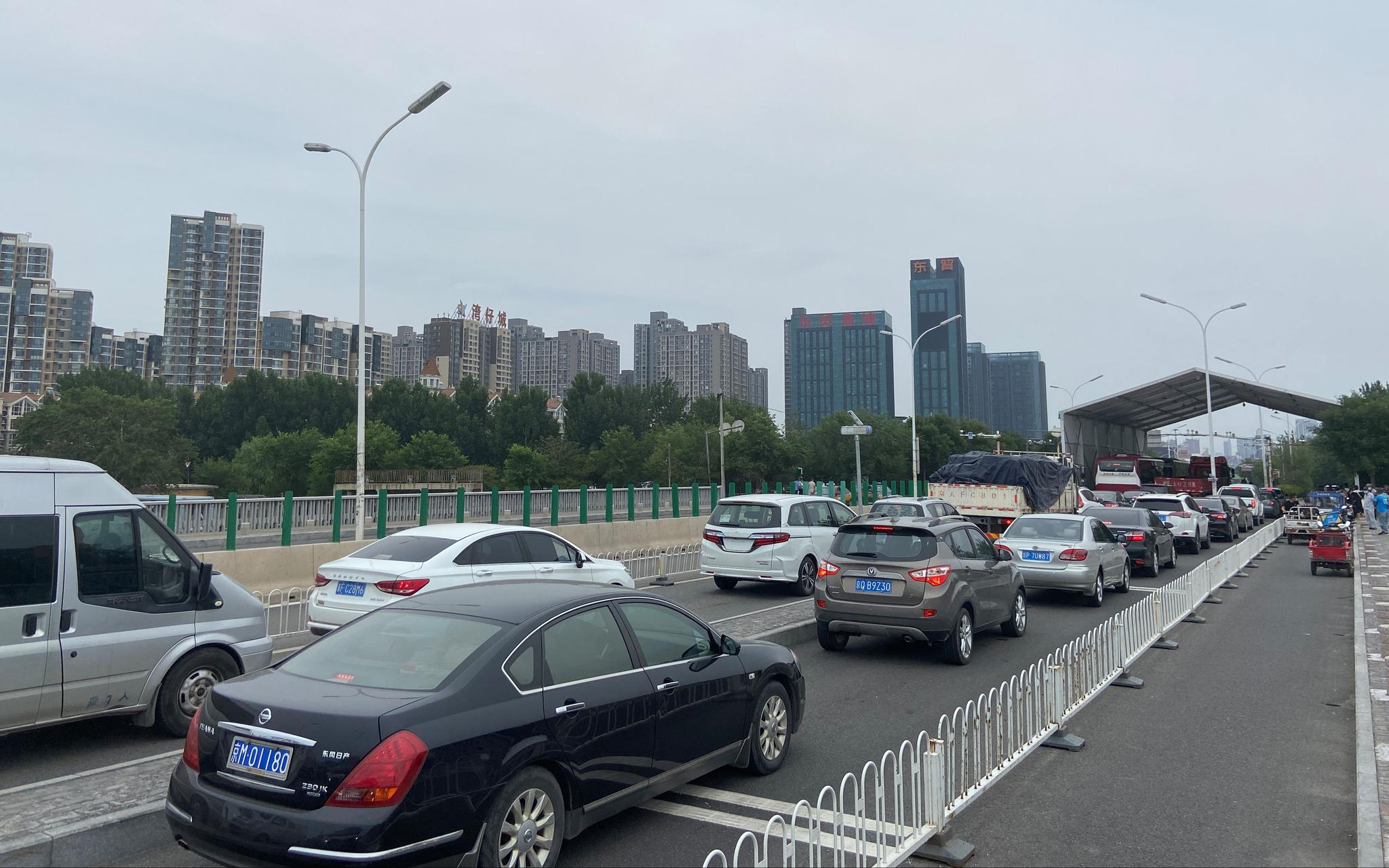  跨越京冀两地的潮白河大桥上，等待出京的车辆排起长队。摄影/新京报记者 王贵彬