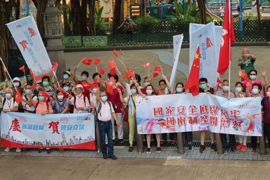 图为:沿途市民手持红旗夹道欢迎