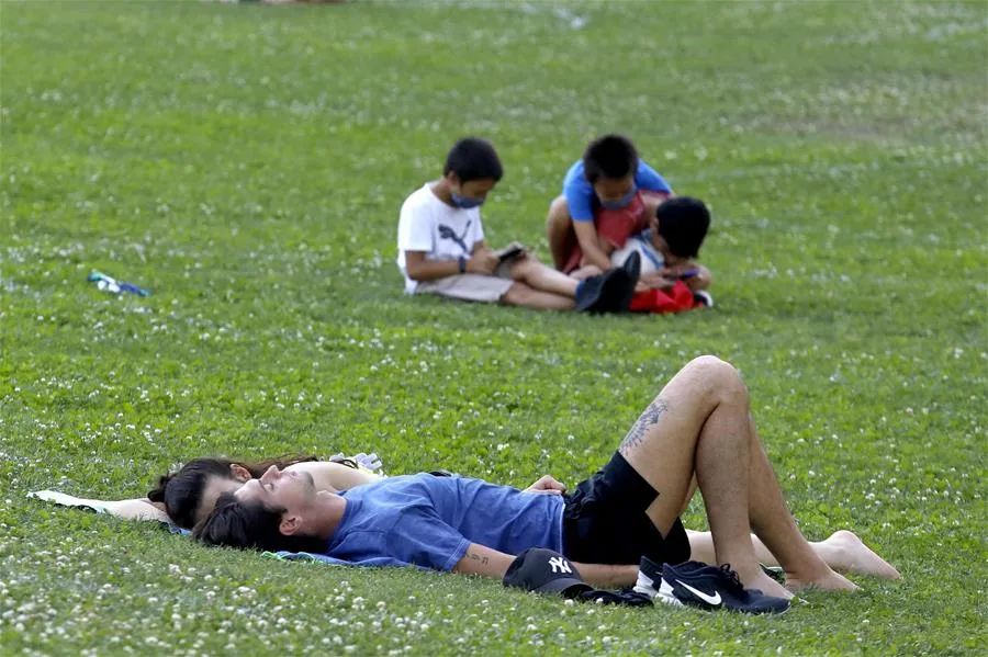 ▲6月29日，人们在意大利米兰的公园草坪上休息。新华社/欧新