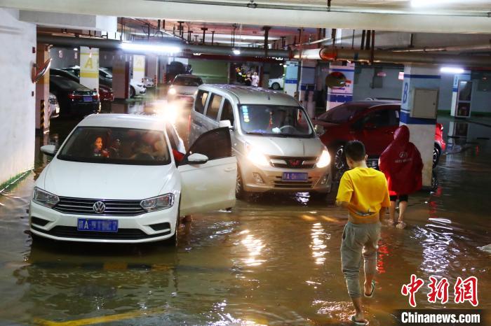 因暴雨倒灌车库，车主把车辆开出受淹的地下车库。　刘占昆 摄