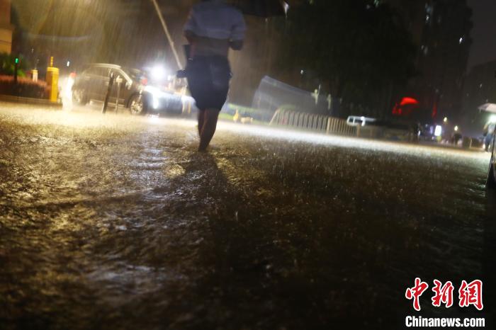图为江西南昌一小区道路积水严重，一名男子涉水前行。　刘占昆 摄