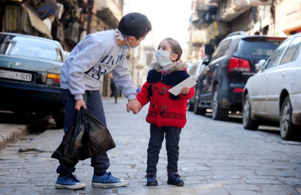 4月12日，在叙利亚大马士革，两名佩戴口罩的儿童走在街头。新华社发