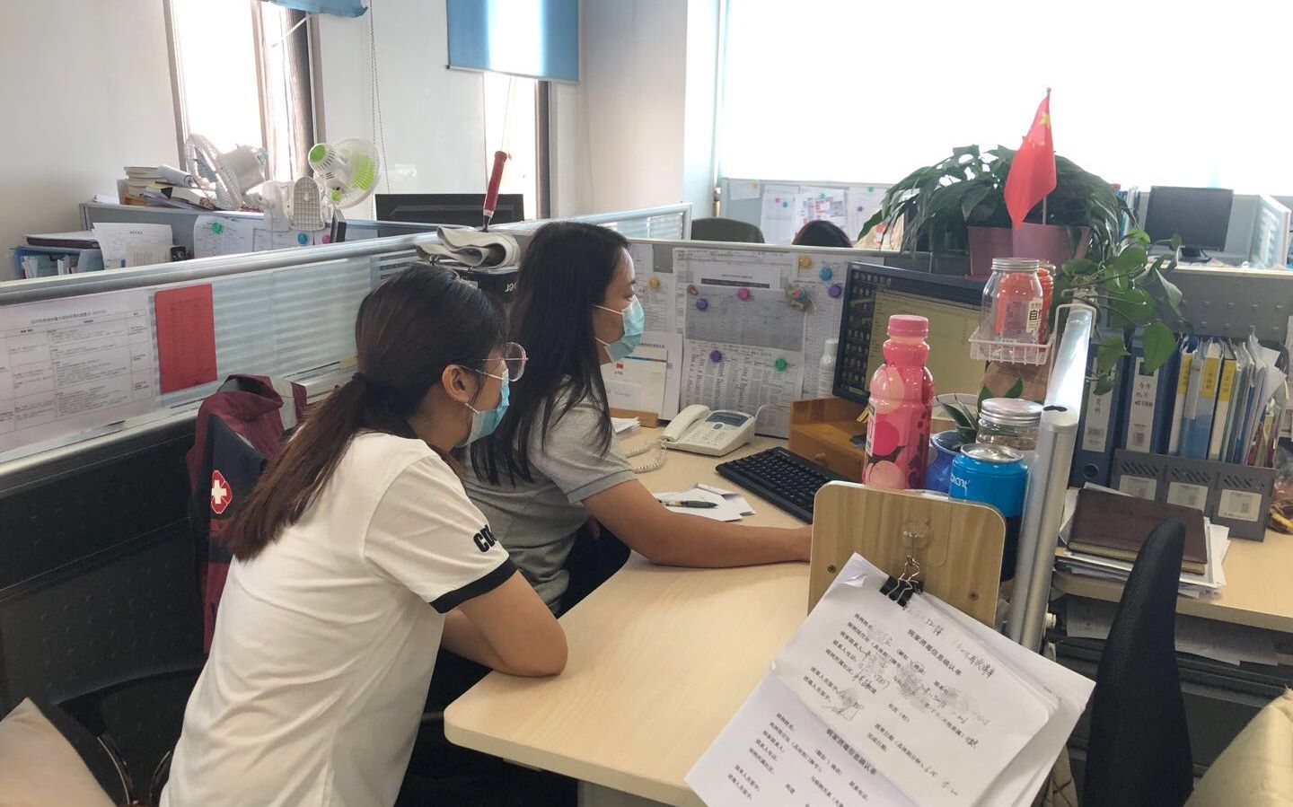 7月8日，金丽娜和倪雪在海淀疾控办公室内查看石景山万达女子的流调报告。新京报记者 韩沁珂 摄