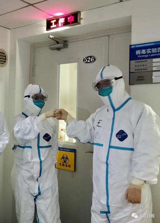  疾控人员准备进入核酸检测实验室。