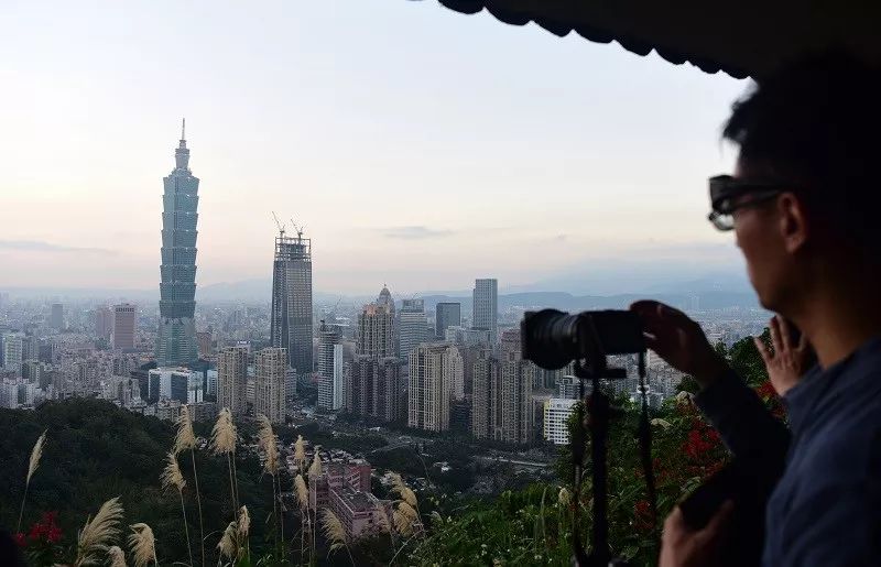  ▲资料图片：游客在台北象山观看拍摄101大厦。（新华社）
