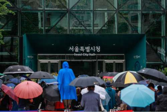 7月13日，在韩国首尔市政府大楼前，市民们冒雨告别已故首尔市长朴元淳。新华社记者 王婧嫱 摄