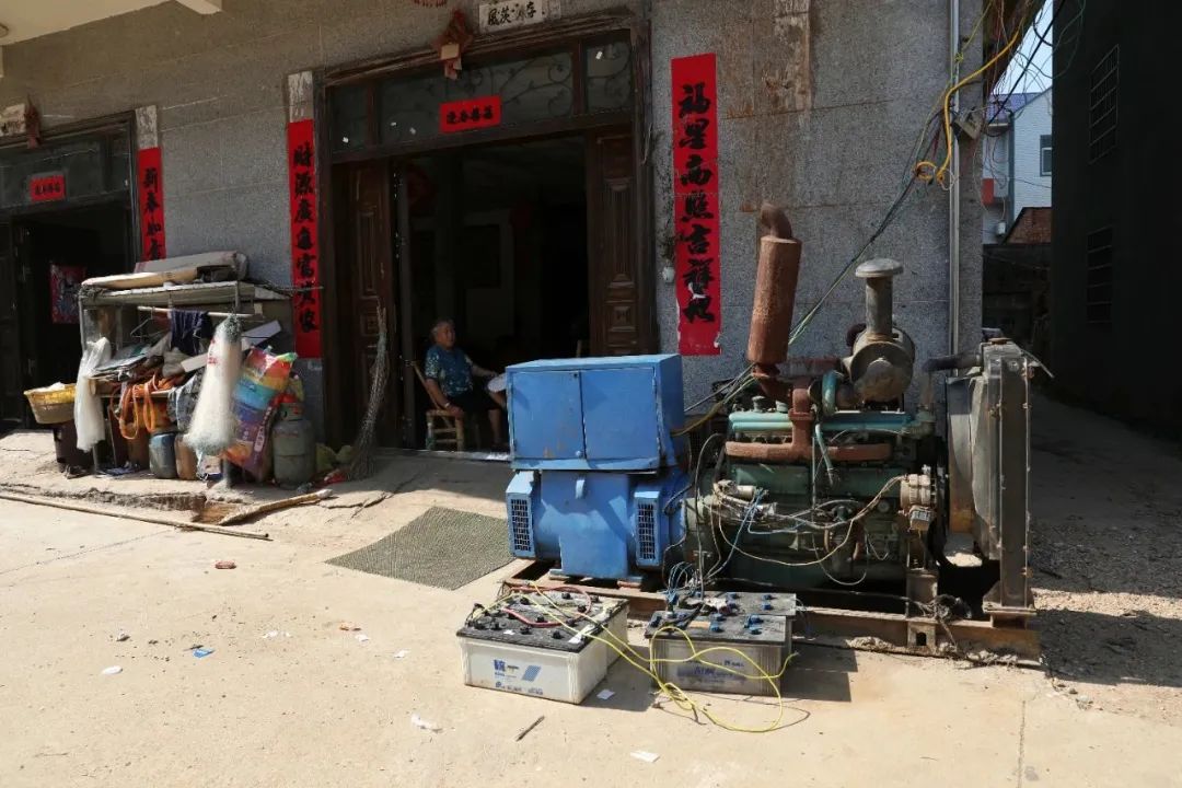 ▲7月14日，藕塘村，村民将渔船上的发电机拆下来供周边十几家村民晚上用。新京报记者 王飞 摄