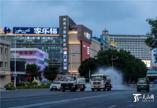  7月20日，乌鲁木齐市南湖路家乐福超市附近，水磨沟区环卫清运队的洒水车正在进行消杀作业。